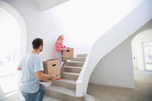 Movers carrying a boxed item carefully through a doorway